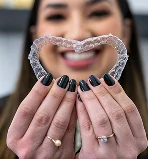 A girl is holding Invisalign Pairs.